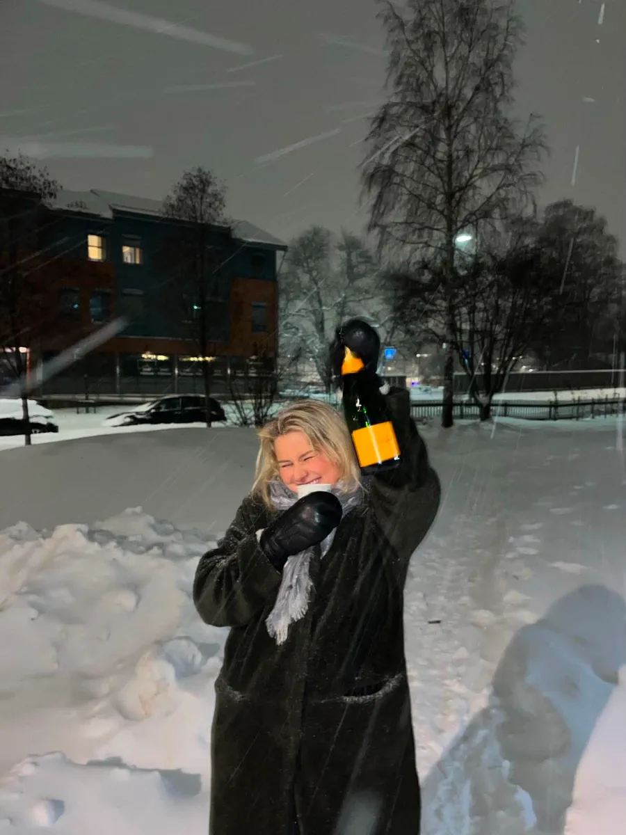 Marie holder opp en flaske ute i snøen.