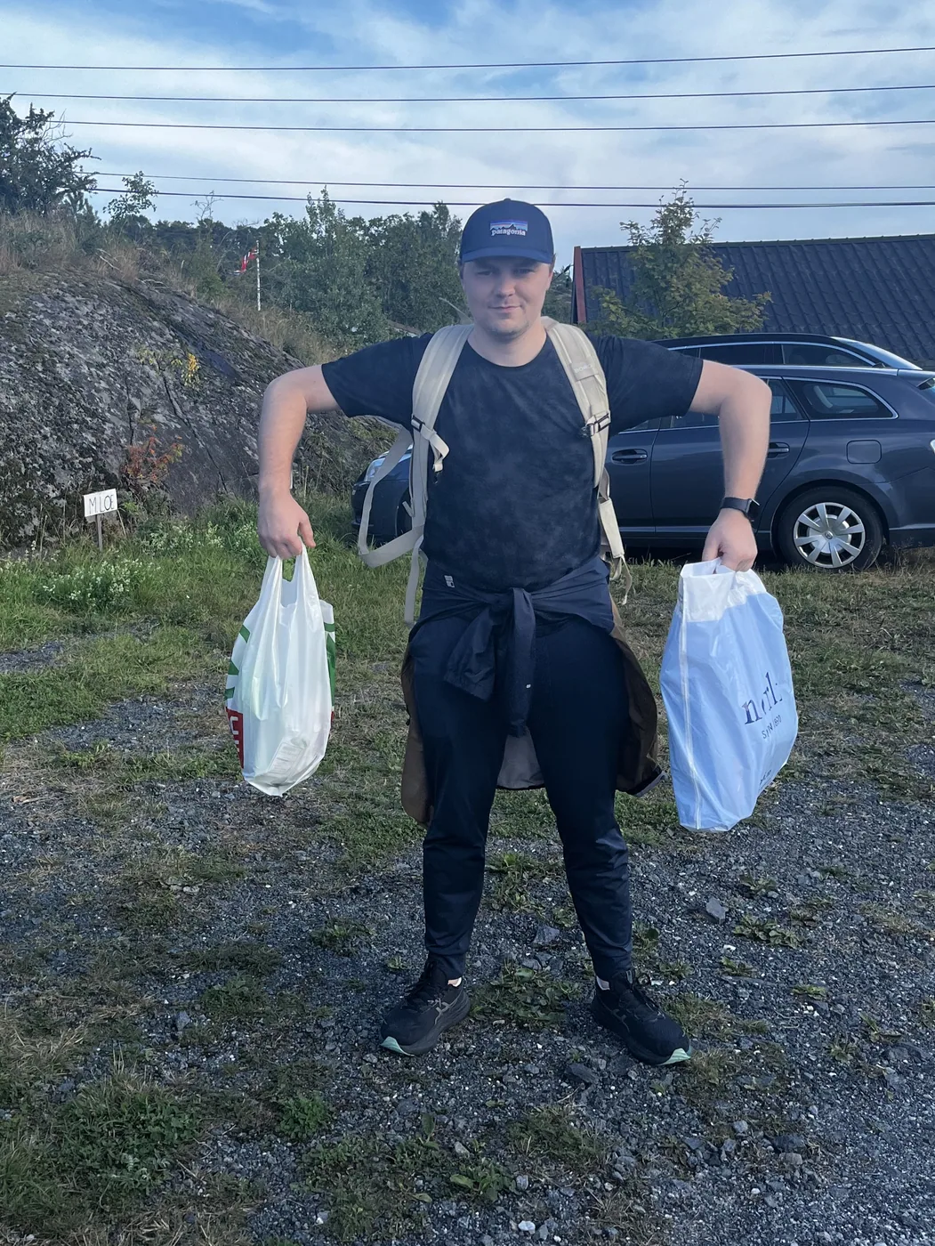 Magnus med ryggsekk og to handleposer.