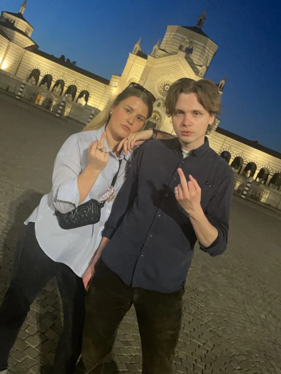 Preben og Marie poserer foran en opplyst bygning om kvelden.
